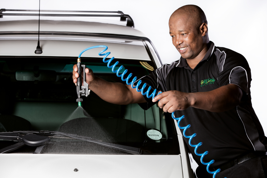 Person cleaning car with spray