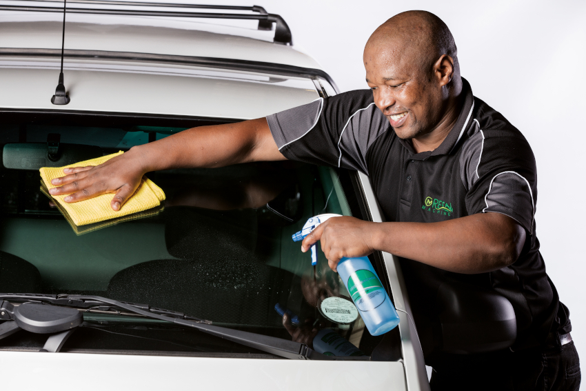 Person cleaning car with spray
